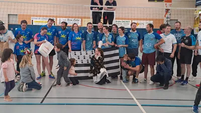 Deuxième photo de groupe autour du drapeau breton et du trophée, avec enfants et supporters.