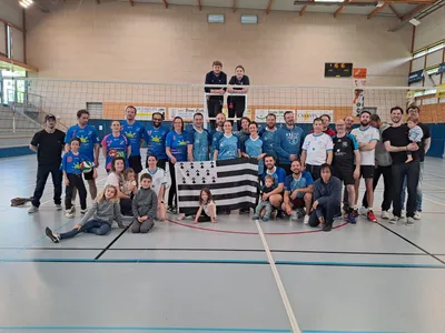 Photo de groupe de l'équipe avec le drapeau breton et le trophée de la Coupe de Bretagne, dans le gymnase.