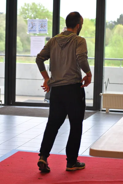 Un homme s'éloigne vers la sortie, sur le tapis rouge installé pour la finale.