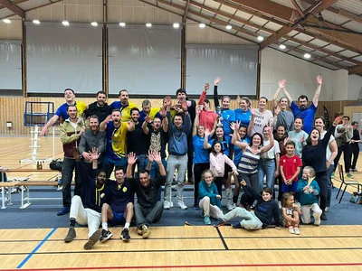Autre photo de groupe de la même célébration, trophée levé au milieu des supporters.