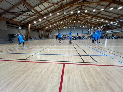 Les joueurs de l'USNC, maillots numérotés, se regroupent autour de leur entraîneur pendant une pause de jeu.
