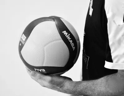 Photo noir et blanc en gros plan : un ballon tenu contre la hanche d'un joueur en maillot sombre.