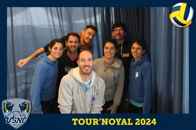 Photo souvenir du photobooth Tour'Noyal 2024 : un groupe de sept joueurs et joueuses pose devant un rideau bleu.