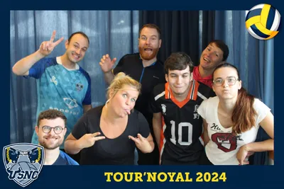 Photo souvenir du photobooth Tour'Noyal 2024 : sept participants posent en faisant des signes et des grimaces.